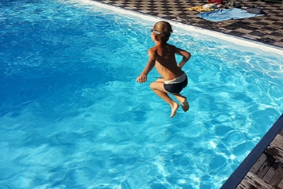 Solar Pool Heating Child jumping into solar heated swimming pool